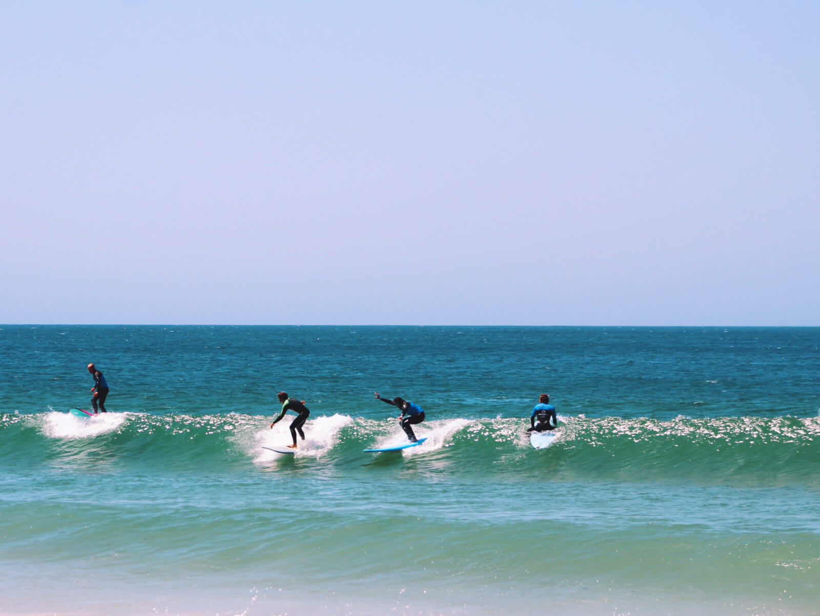 4 surfers on the wave riding a party wave